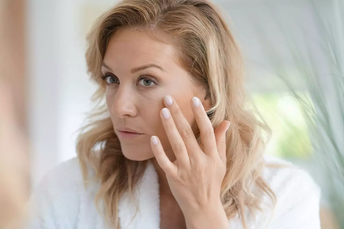 Woman running her finger across her wrinkles