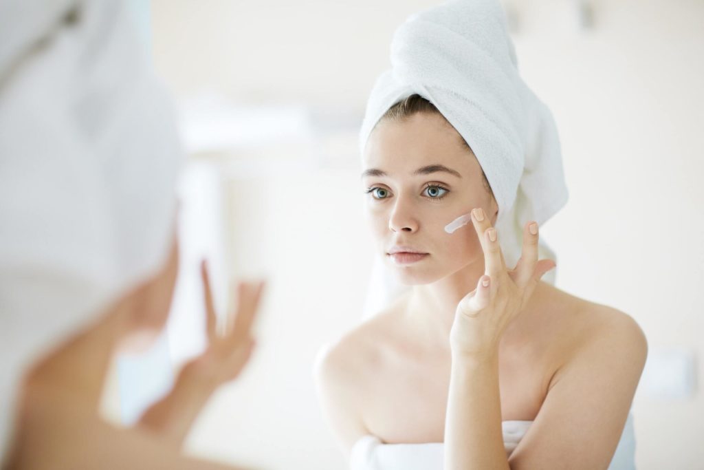 Woman applying skincare product to her face